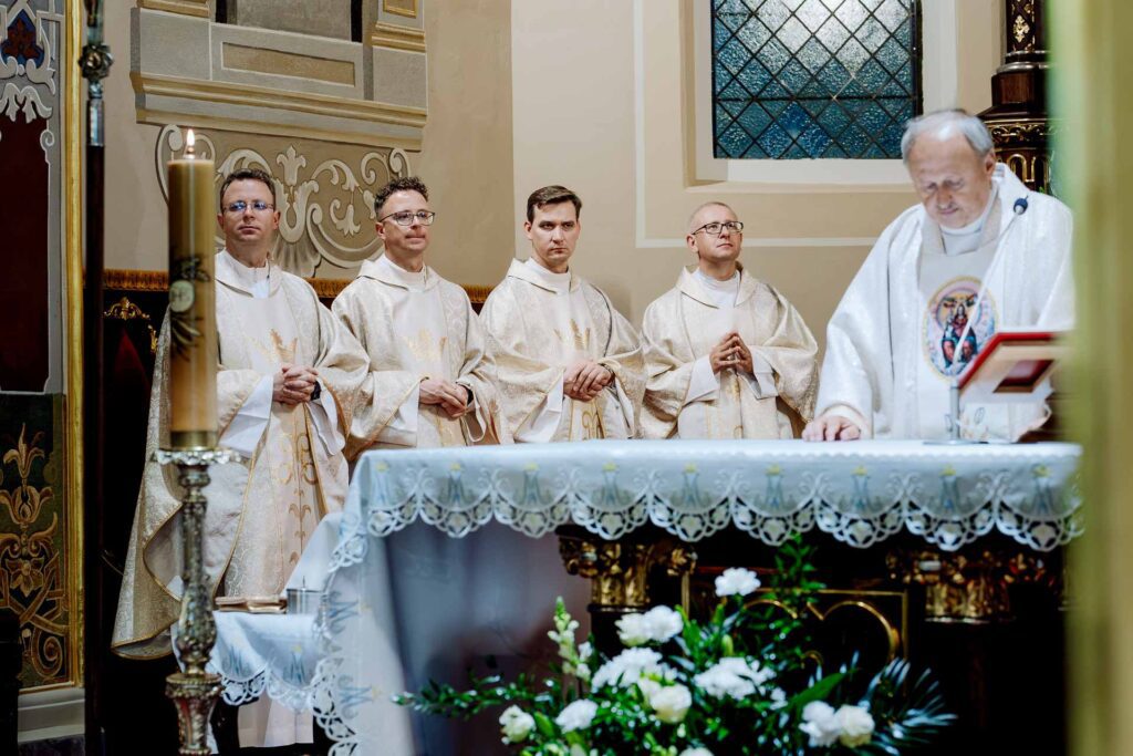 Księża zgromadzeni przy ołtarzu podczas mszy ślubnej.
