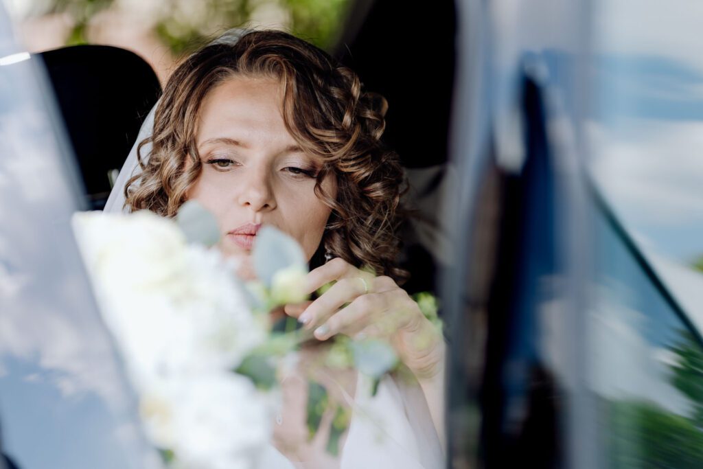 Portret Panny Młodej w samochodzie ślubnym.